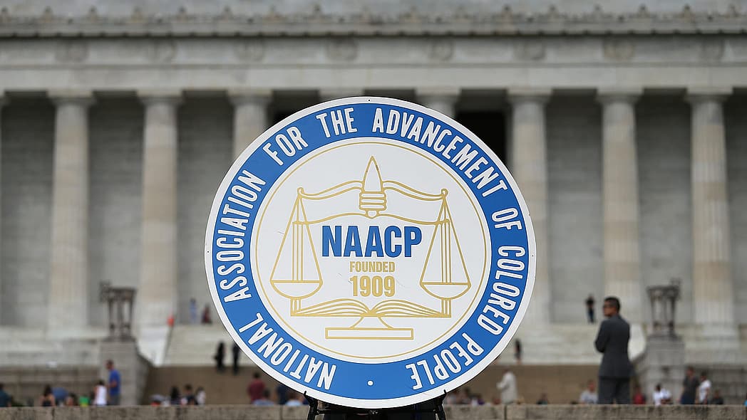 WASHINGTON, DC - JUNE 15: A logo is seen for the National Association for the Advancement of Colored People as NAACP President and CEO Cornell William Brooks speaks during a press conference at the Lincoln Memorial June 15, 2015 in Washington, DC. Brooks announced "America's Journey for Justice," an 860-mile march from Selma, Alabama to Washington, D.C. and a campaign "to protect the right of every American to a fair criminal justice system, uncorrupted and unfettered access to the ballot box, sustainable jobs with a living wage, and equitable public education." (Photo by Win McNamee/Getty Images) theGrio.com