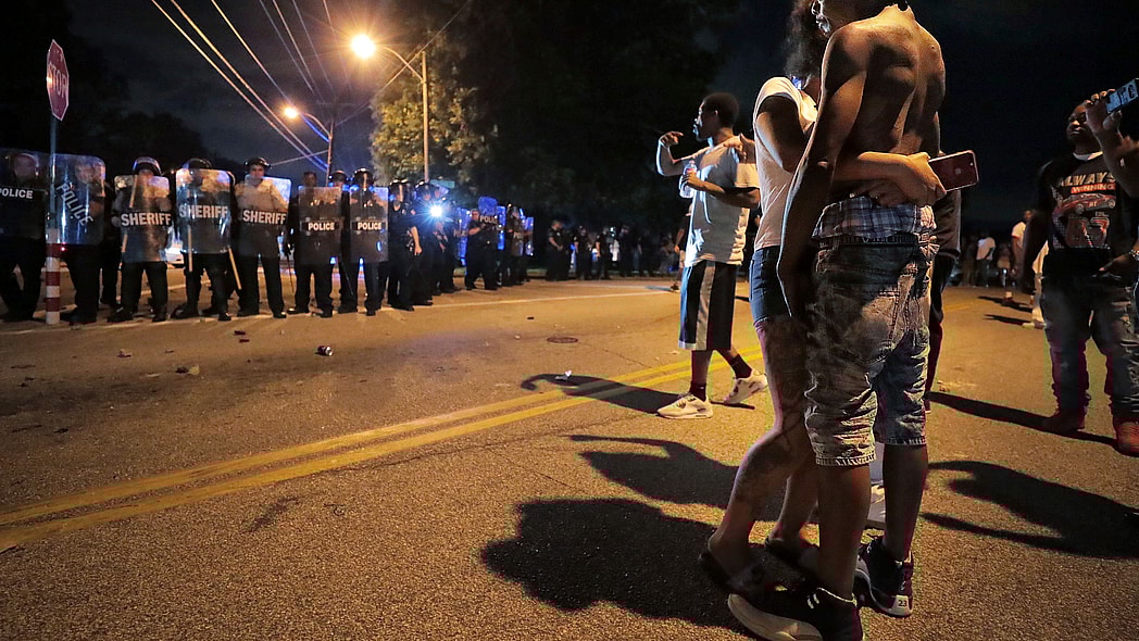 A man identified as Sonny Webber, right, father of Brandon Webber who was reportedly shot by U.S. Marshals earlier in the evening, joins a standoff as protesters take to the streets of the Frayser community in anger against the shooting, Wednesday, June 12, 2019, in Memphis, Tenn. (Jim Weber/Daily Memphian via AP)