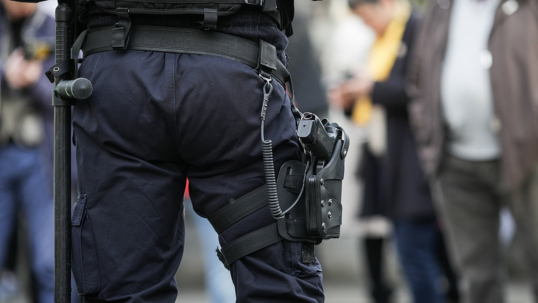 Details of the security kit of a riot police officer (including handcuffs, 9mm handgun, radio station and baton)