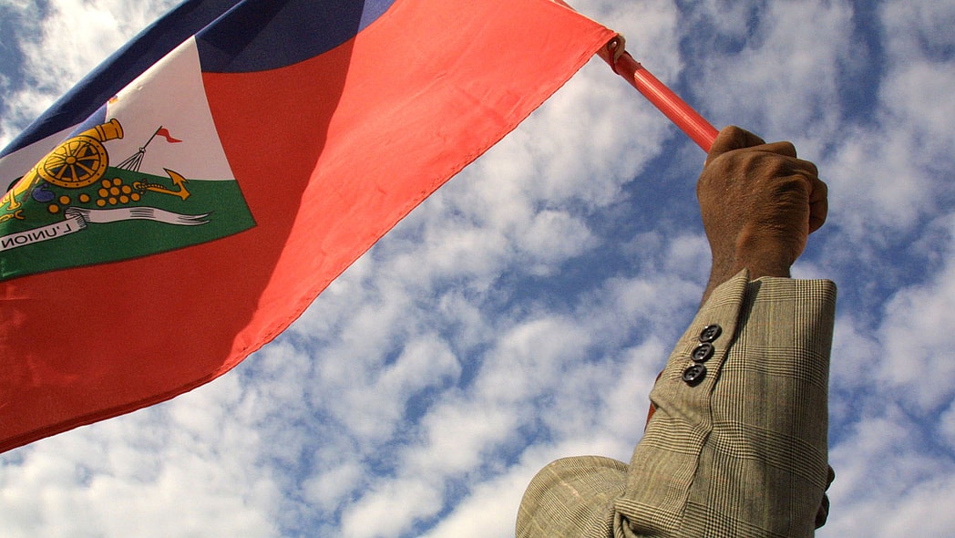 A man holds a Haitian flag