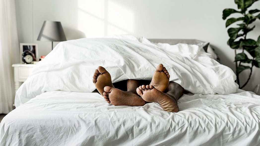 Black couple lying on bed together