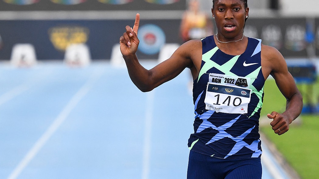 South African track star Caster Semenya points upward as she rounds the track