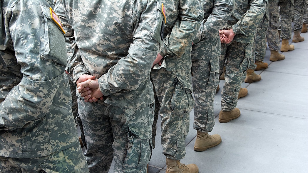 A line of soldiers wearing camouflage