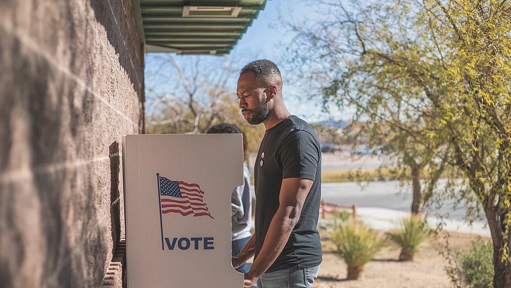 A man stands at a voting drop box