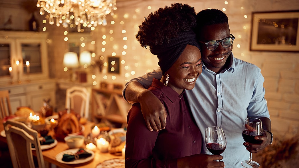 A smiling couple holding glasses of wine