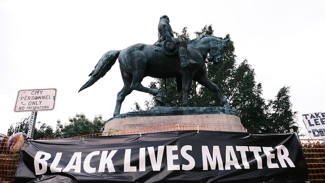 The statue of Robert E Lee with a banner that reads "Black Lives Matter"