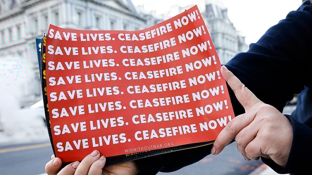 Posters reading "Save lives. Ceasefire now!"