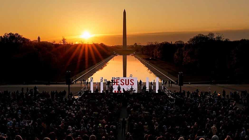 The word "Jesus" is displayed on a large monitor at an Easter sunrise service