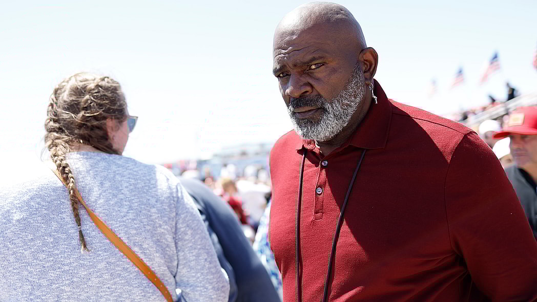 A tiny graduation cap on a pile of $100 bills