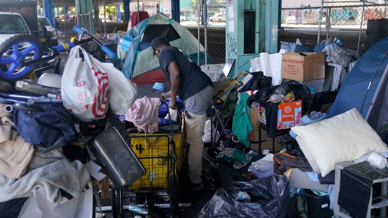 Michael Johnson gathers possessions at a homeless encampment