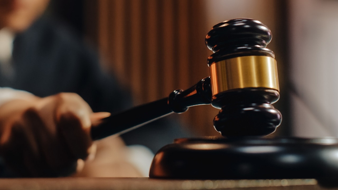 A hand striking a gavel on a sound block