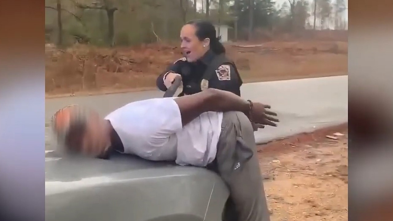 A police officer uses a stun gun on Micah Washington after he was handcuffed
