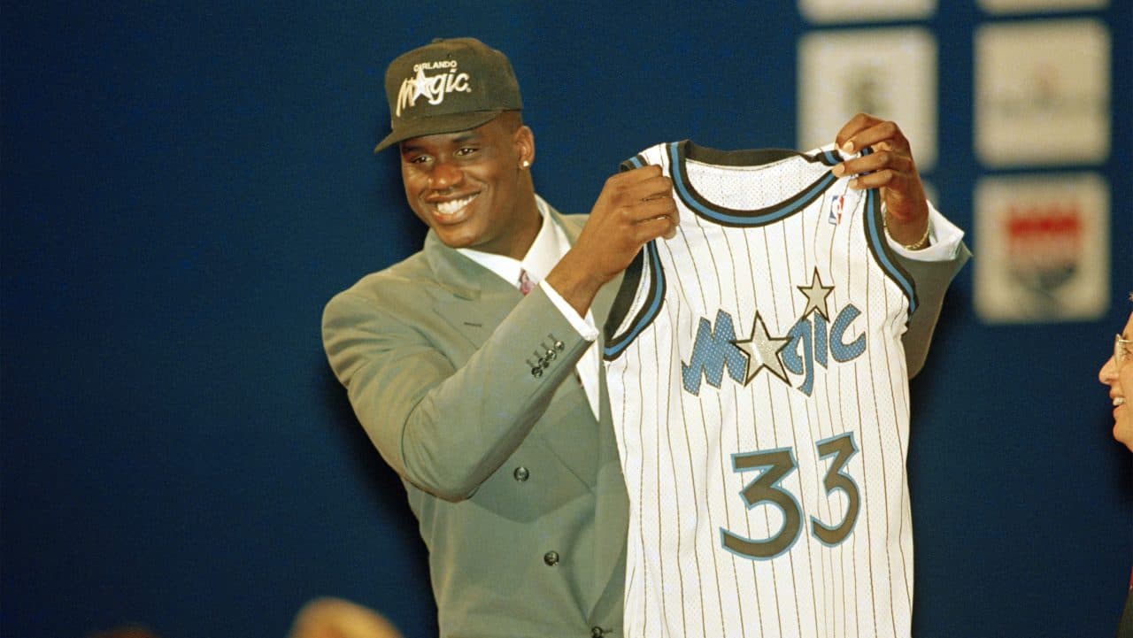 Basketball player Shaquille O'Neal holds up his Orlando Magic jersey