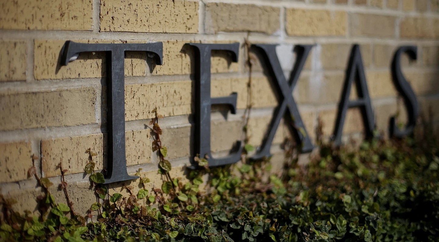 Ivy grows near the lettering of an entrance to the University of Texas