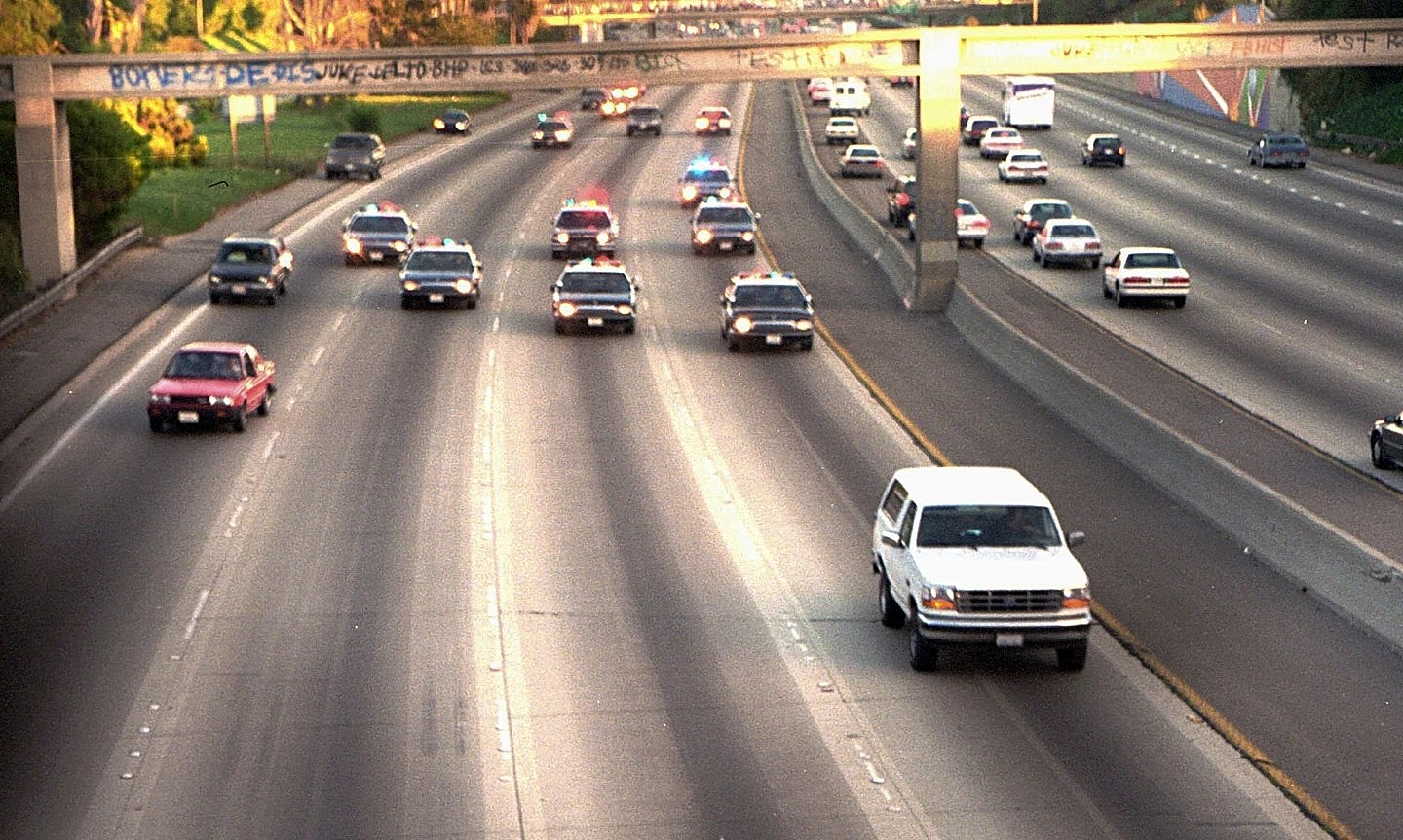 A white Ford Bronco, driven by Al Cowlings carrying O.J. Simpson, is trailed by Los Angeles police cars