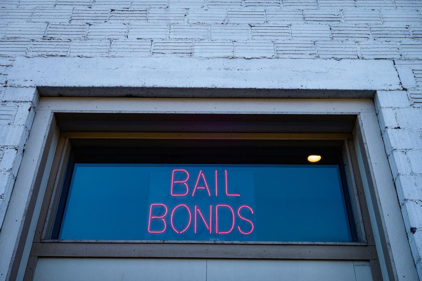 A neon sign reading "Bail Bonds"