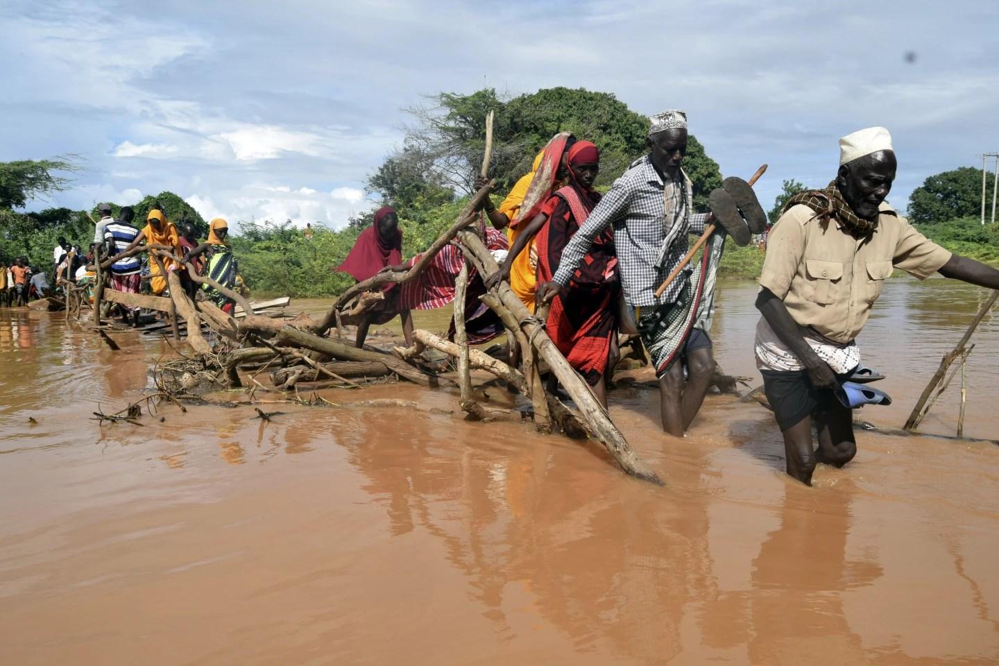 Residents of Chamwana Muma village walk through flood water