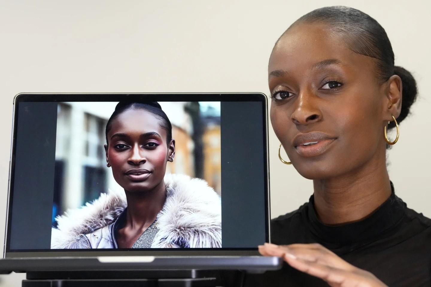 Fashion model Alexsandrah poses with a computer showing an AI generated image of her