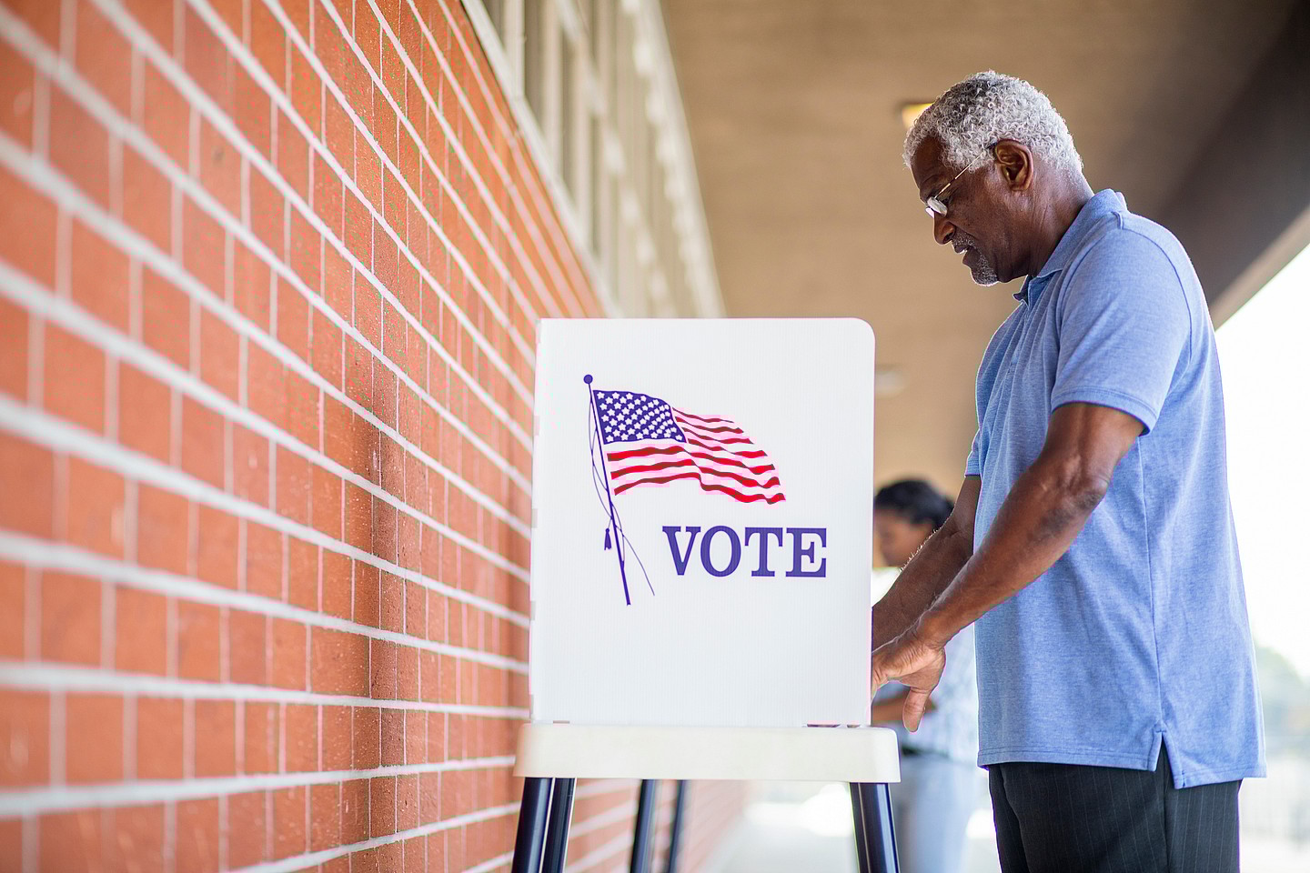 A man stands at a voting booth