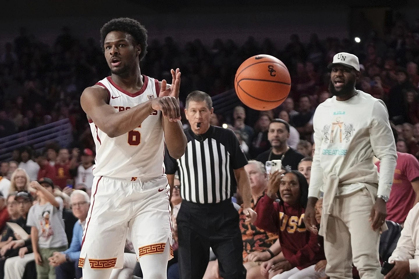 Southern California guard Bronny James passes the ball as his father LeBron James watches