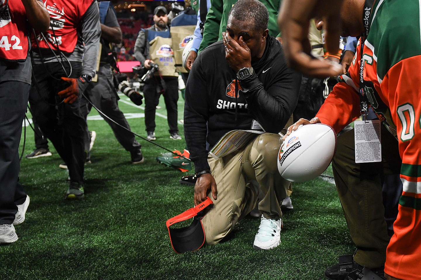 Florida A&M Head Coach Willie Simmons kneels on the ground