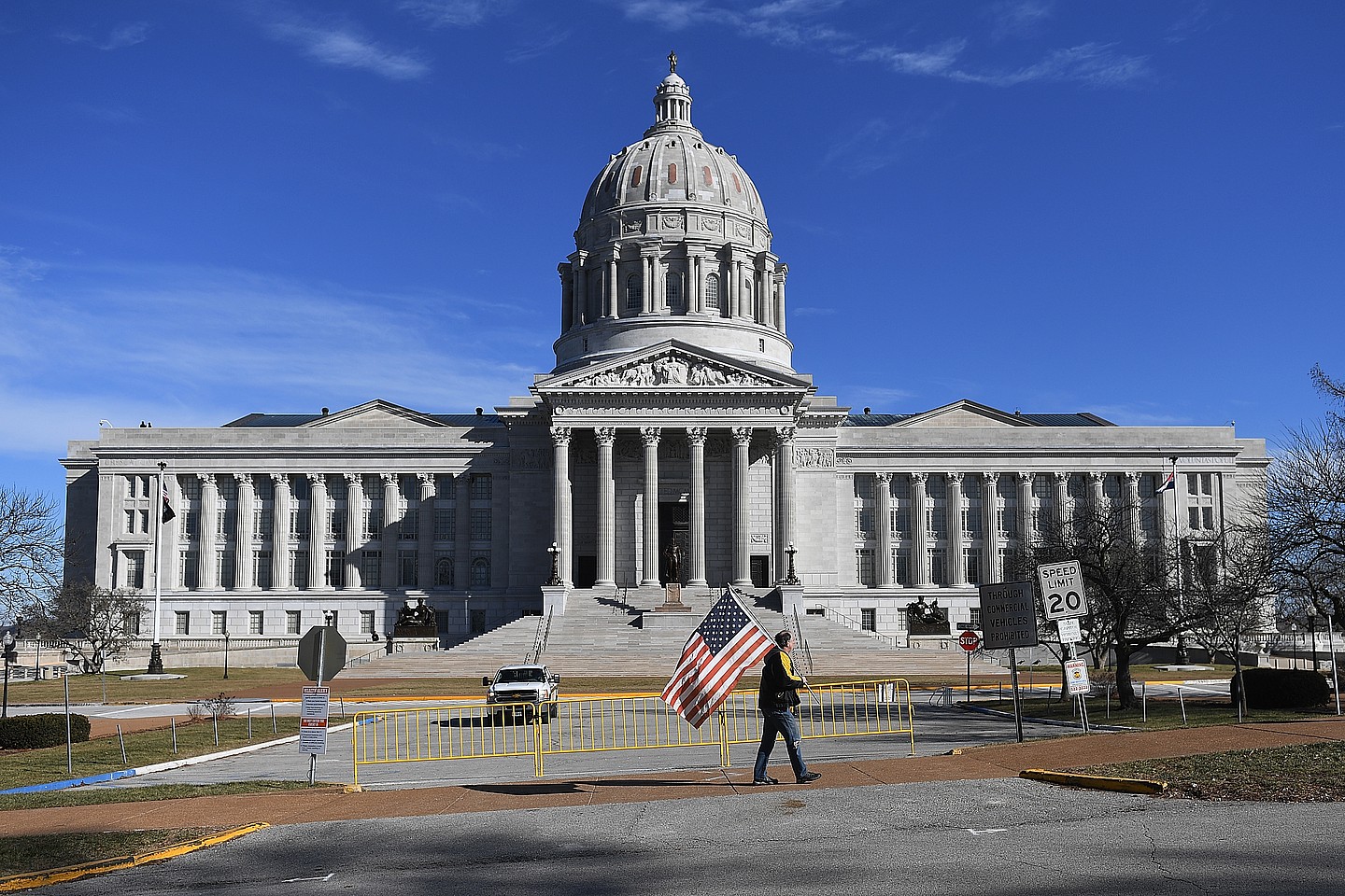 A man waves an American flag outside the Missouri State Capitol building