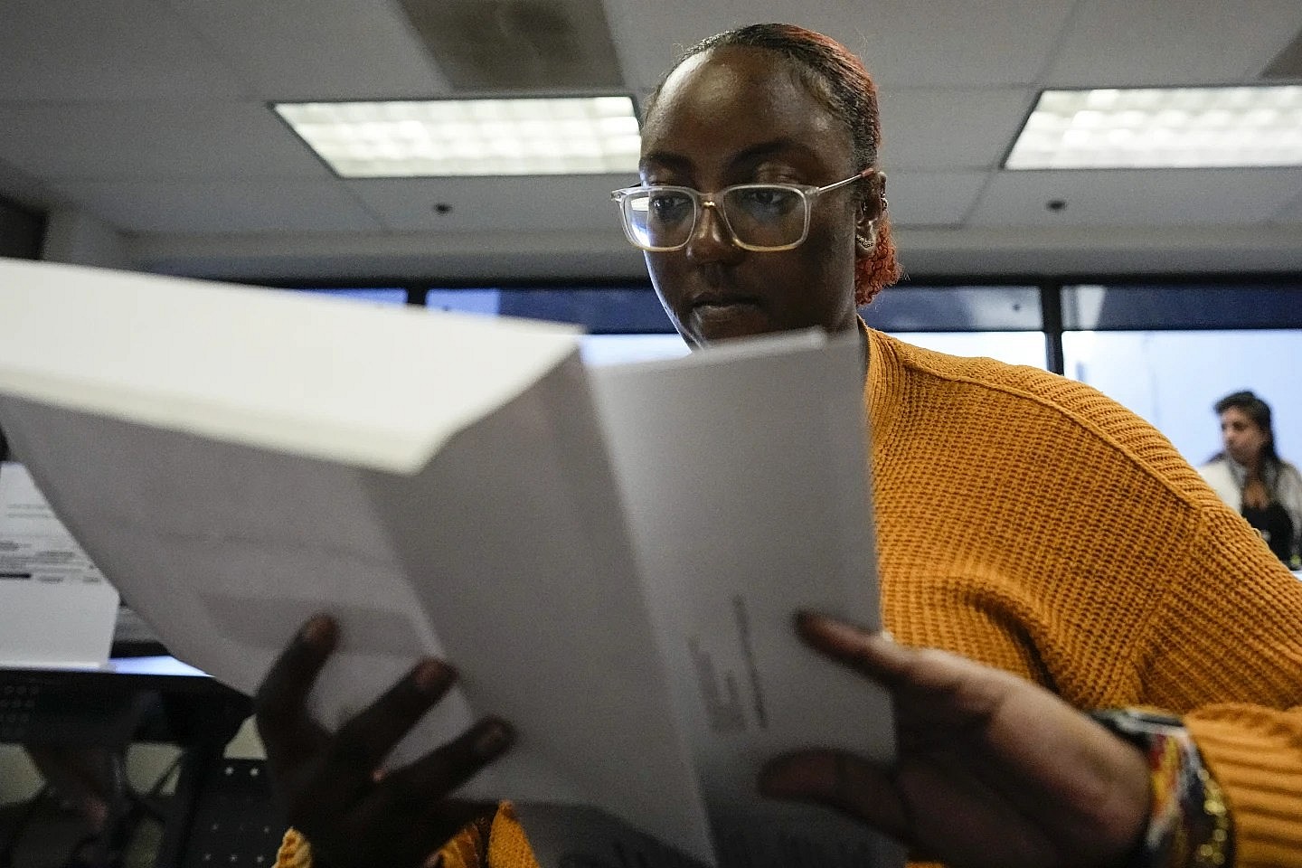 Elections assistant Mikayla Riley works in the processing center during early voting