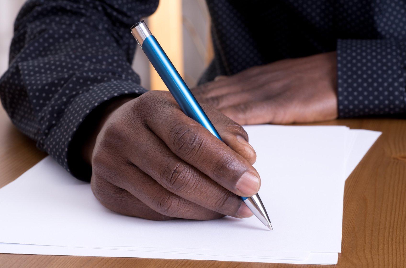 Man writing with a pen thegrio.com