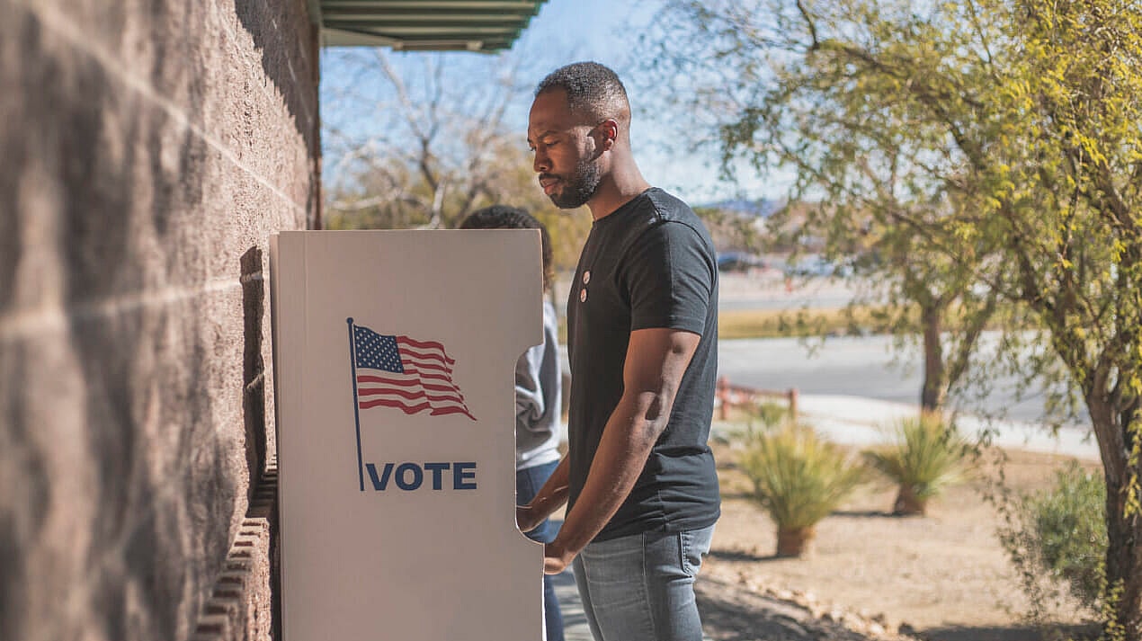 A man stands at a voting drop box