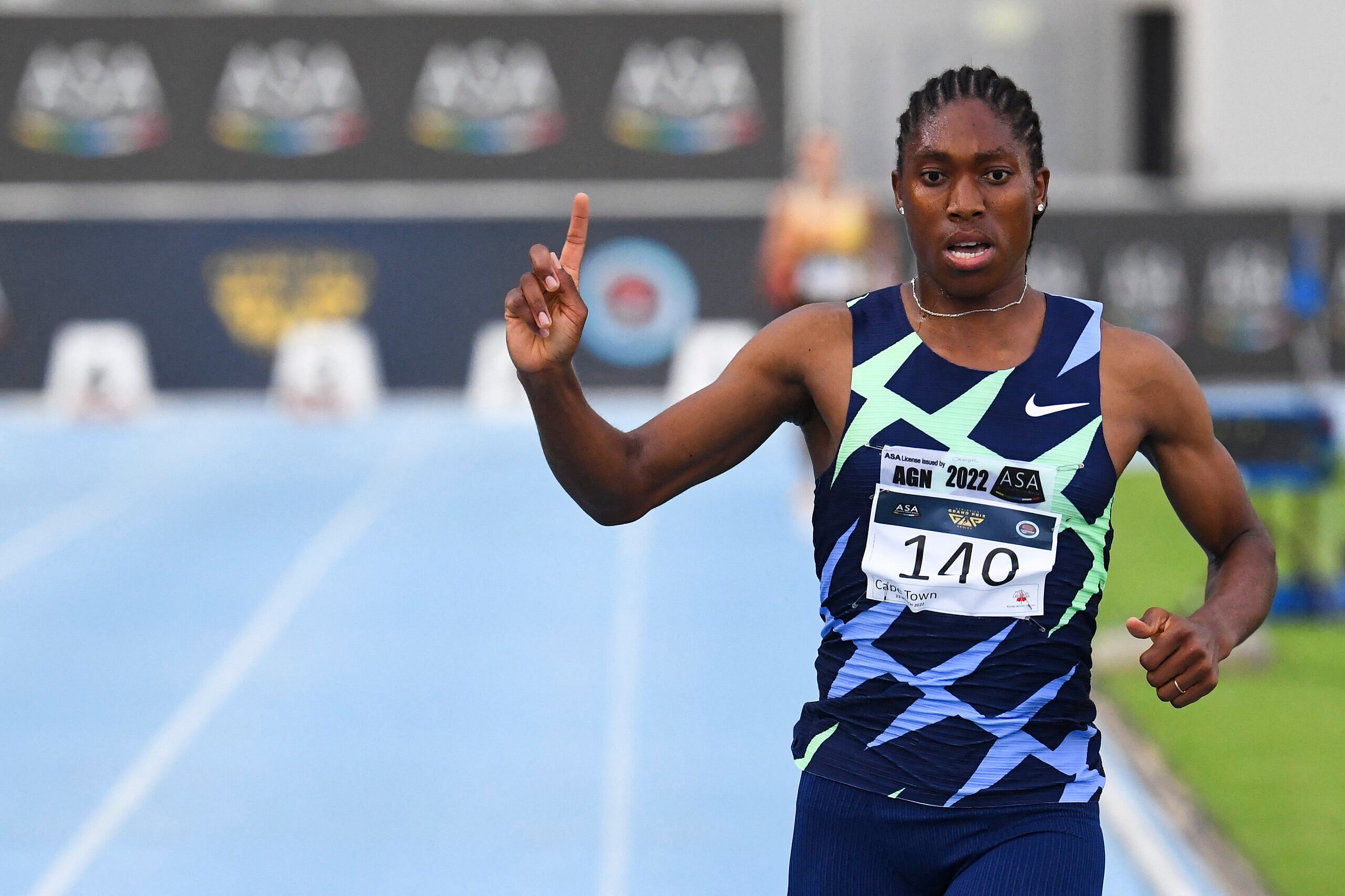South African track star Caster Semenya points upward as she rounds the track