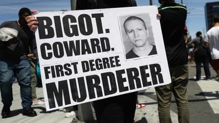 A protester holds a sign with a photo of former Minneapolis police officer Derek Chauvin