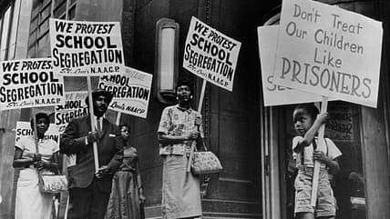Demonstrators picket in front of a school board office protesting segregation