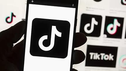 The TikTok logo is shown on a cell phone