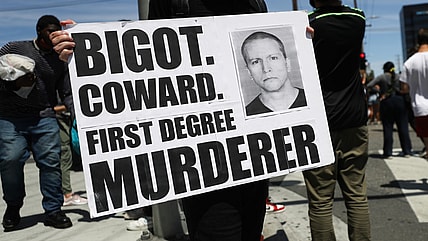 A protester holds a sign with a photo of former Minneapolis police officer Derek Chauvin