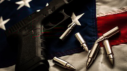 A gun and bullets on an American flag