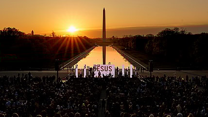 The word "Jesus" is displayed on a large monitor at an Easter sunrise service