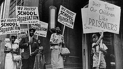 Demonstrators picket in front of a school board office protesting segregation