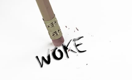 The eraser end of a pencil by the word "Woke"