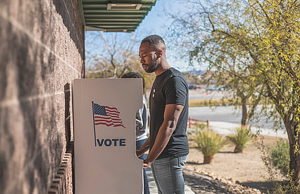 A man stands at a voting drop box