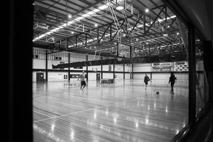 basketball court with three men practicing