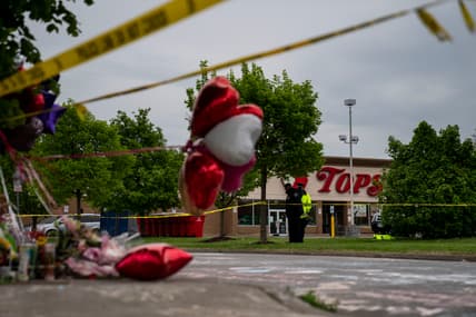 People gather at the scene of a mass shooting at Tops Friendly Market
