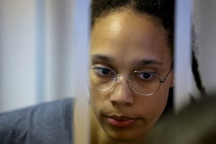WNBA star and two-time Olympic gold medalist Brittney Griner stands in a cage in a courtroom in Russia
