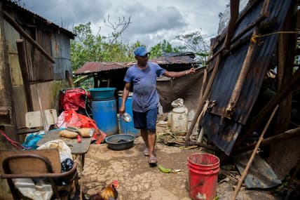 A man checks damages in a house near the highway