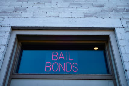 A neon sign reading "Bail Bonds"