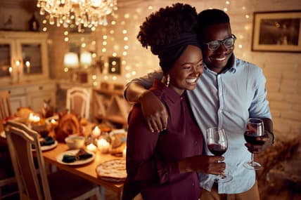 A smiling couple holding glasses of wine