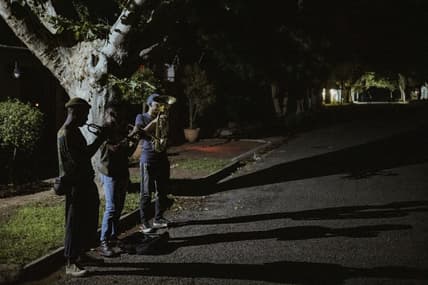 Members of The Middle of the Road Band Smiso, Franqo and Pro, play Christmas carols in Johannesburg