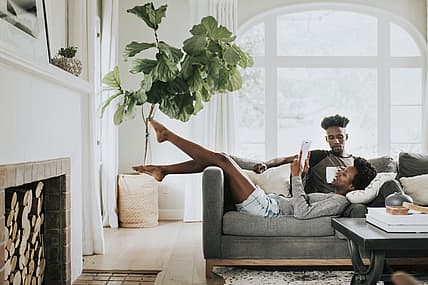 Black couple reading a book on the couch
