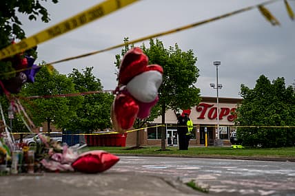 People gather at the scene of a mass shooting at Tops Friendly Market
