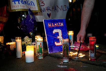 A memorial for Buffalo Bills safety Damar Hamlin showing candles and a plaque