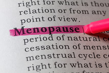 A dictionary page with the word "menopause" highlighted in pink